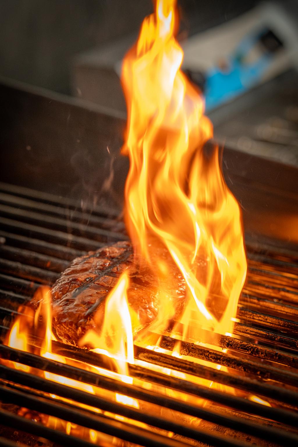 Premium steak searing over open flame on the grill