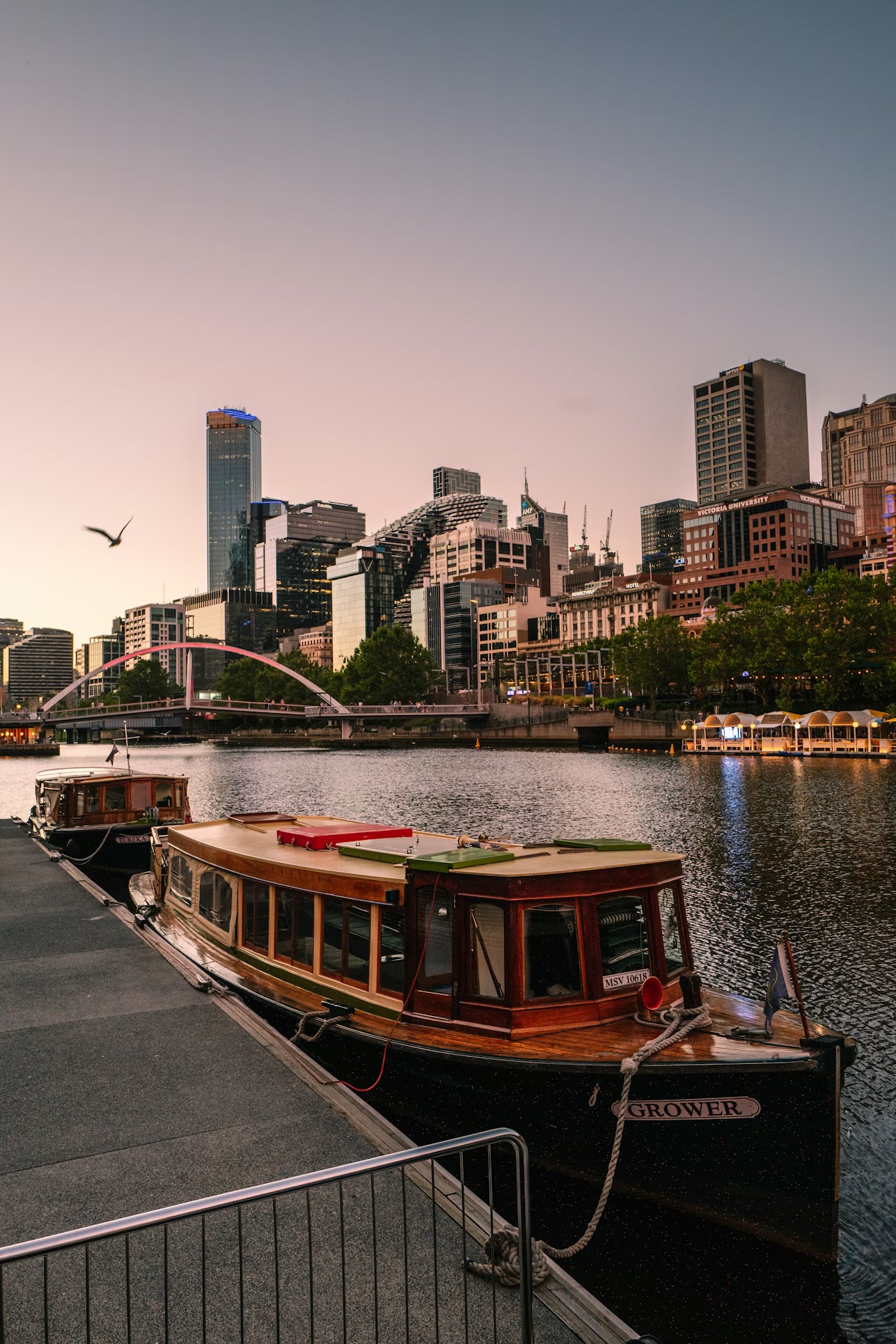 Melbourne city skyline at dusk over the Yarra River with moored boats